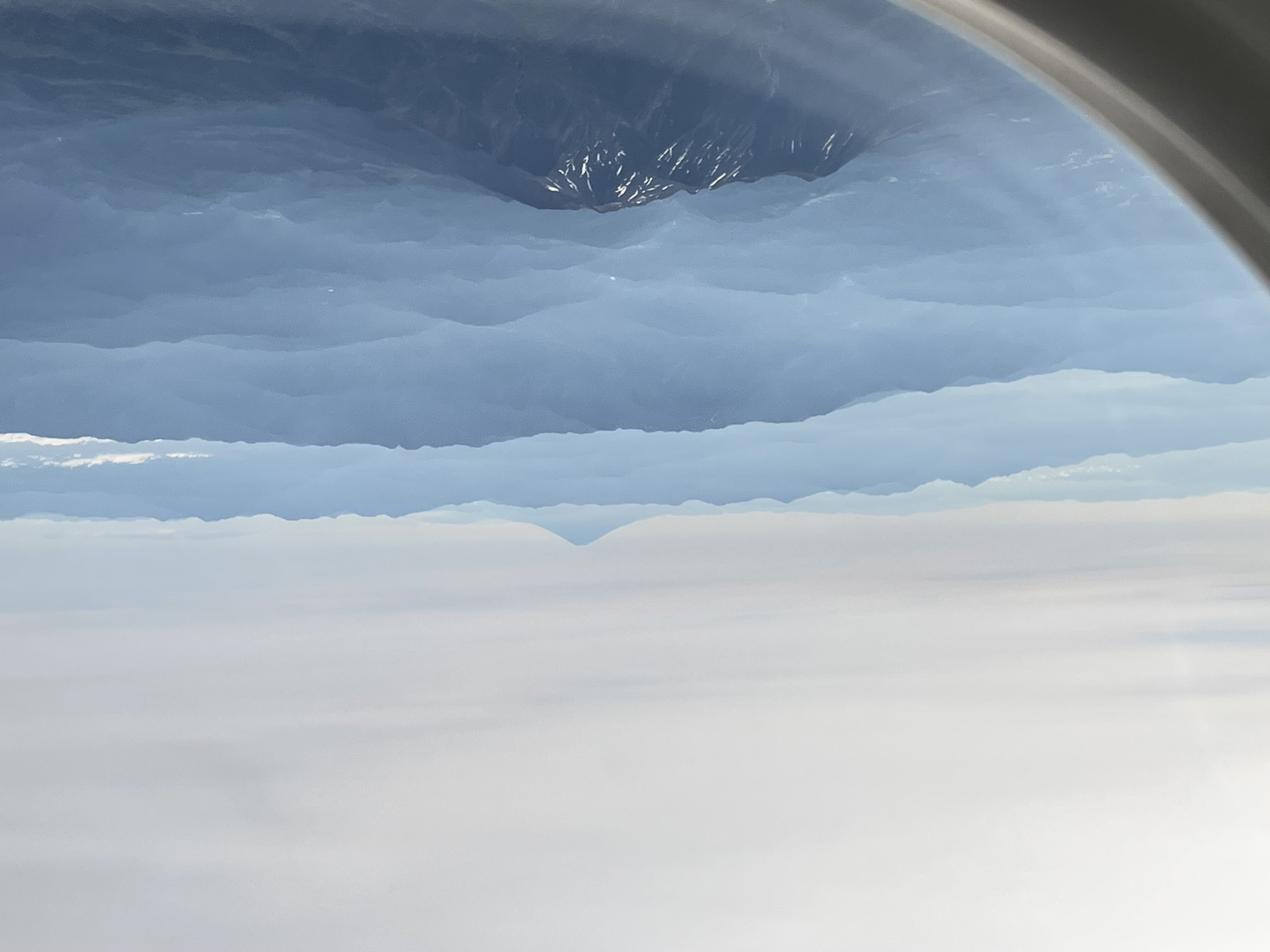 飛行機の窓から見える雲と山